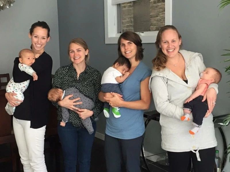 Four families from one class, each holding their baby