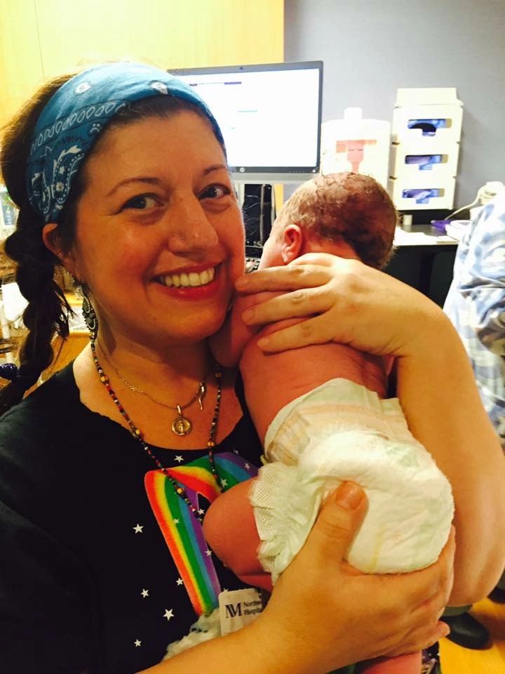 Rita holding a newborn, smiling
